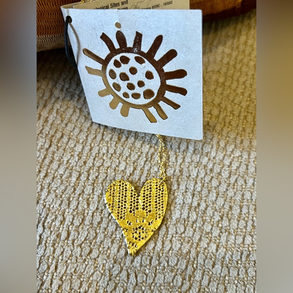 Lace & luster combined to create this heart necklace dipped in 24k gold.